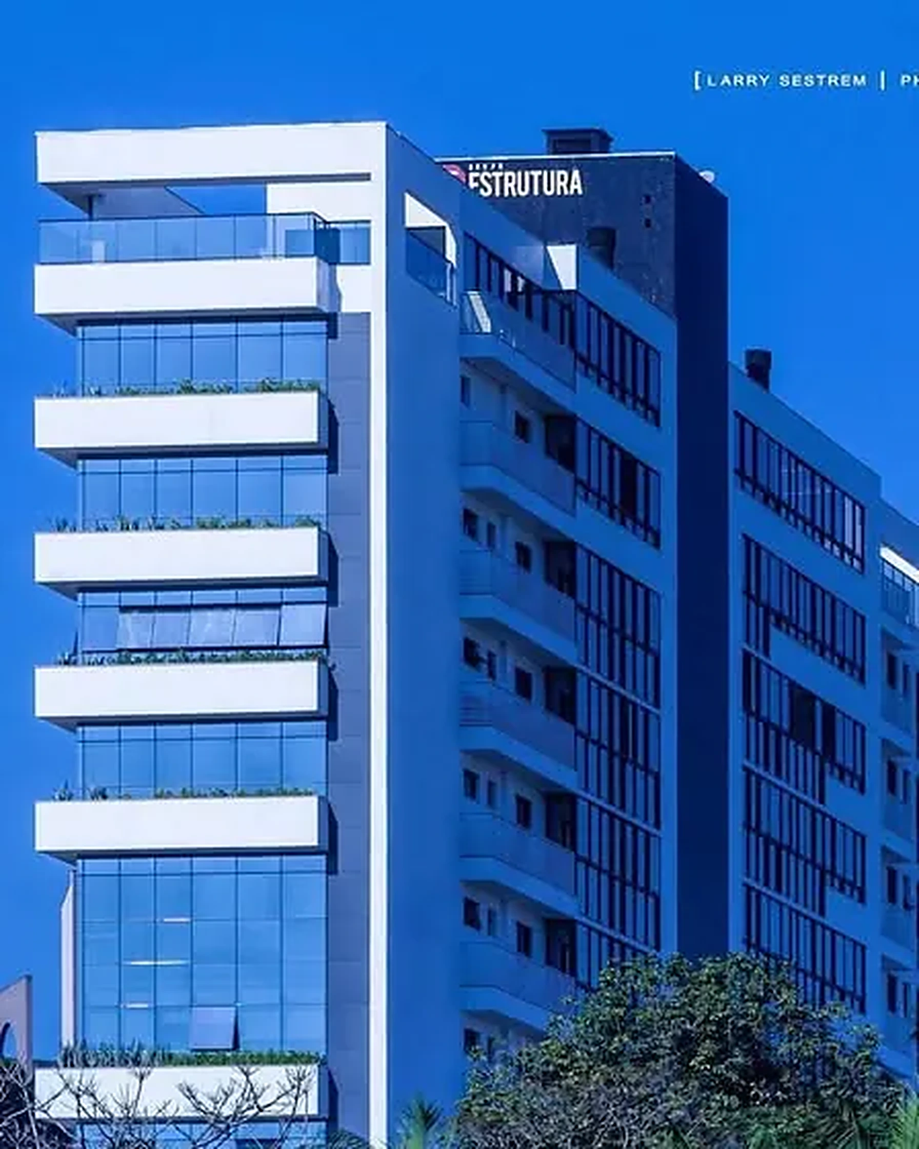 Edifício residencial branco com fachada de vidro contra o céu azul